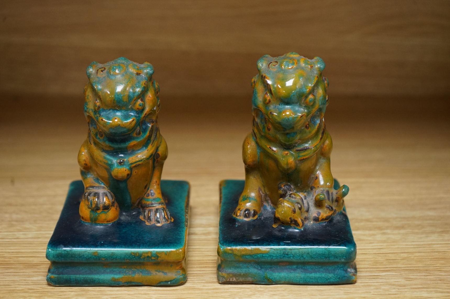 A pair of Chinese turquoise and olive green glazed ceramic lion dogs, Guandong kilns, 19th/20th century, impressed mark, 12cm